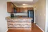 Charming kitchen with rustic wood accents, sleek appliances, and warm cabinetry for a cozy ambiance.