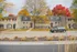 Elegant apartment building surrounded by vibrant autumn trees, featuring charming brickwork and inviting entrances, perfect for comfortable suburban living.