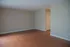 Spacious open living area with elegant hardwood flooring and neutral wall tones, perfect for custom decor.