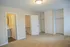 Bright, spacious bedroom with plush carpeting, ample closet space, and elegant neutral tones.