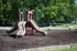 Inviting playground with modern slides and playful ride-on toys set in a lush green park area.