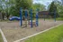 Charming playground with vibrant blue structures surrounded by lush greenery, offering an inviting space for family fun.