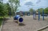 Charming community playground with modern play structures surrounded by lush greenery, ideal for family living.