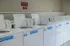Spacious and modern laundry room equipped with multiple high-efficiency washing machines in a bright and clean environment.