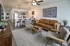 Modern open-plan living space with cozy leather sofa, sleek kitchen, and stylish bar seating, perfect for entertaining.