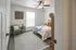 Inviting bedroom with modern decor, featuring a cozy bed with white linens, stylish armchair, and bright window for natural light.