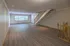 Spacious living room with elegant staircase, natural light flooding through large windows, and sleek hardwood floors.