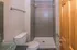 Modern bathroom featuring a sleek glass sink, elegant tiled shower, and a cozy wooden door entrance.