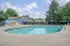 Inviting outdoor pool surrounded by lush greenery and vibrant mural, perfect for relaxation and leisure.