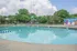 Inviting outdoor pool area with clear blue water, surrounded by colorful murals and lush greenery, perfect for relaxation and leisure.