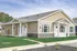 Charming single-story home with beige siding, white trim, and well-maintained green lawn, perfect for modern suburban living.