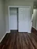 Inviting bedroom with elegant wood flooring and a spacious closet, showcasing modern living.