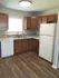 Inviting kitchen with warm wood cabinetry, elegant backsplash, and sleek appliances, ideal for any culinary enthusiast.