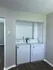 Modern laundry nook with sleek washer and dryer perfectly integrated into a spacious living area, featuring elegant hardwood flooring.