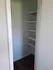 Charming small closet with built-in shelves and smooth wooden flooring, perfect for organized storage in a cozy apartment.