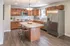 Modern kitchen featuring elegant wooden cabinetry, sleek countertops, and a central island for casual dining.