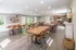 Bright and spacious community dining area with wooden tables, modern decor, and a well-equipped kitchen in the background.