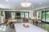 Elegant communal dining area with modern decor, abundant natural light, and inviting wooden tables, offering a perfect setting for gatherings.