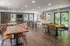 Modern community room with wooden tables, ample seating, and natural light from large windows, perfect for gatherings.