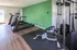 Modern apartment gym with high-quality treadmills and versatile weight machine, featuring bright natural light and sleek wooden flooring.