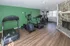 Inviting home gym with modern exercise equipment, featuring a treadmill, elliptical, and weight machine on sleek wooden flooring and a cozy stone fireplace.