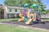 Inviting playground with vibrant slides and climbing structures, set in a lush apartment community.