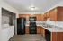 Modern kitchen with sleek black appliances, abundant wooden cabinetry, and convenient in-unit washer and dryer.