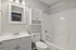 Bright, modern bathroom with sleek white fixtures, elegant vanity mirror, and stylish lighting.