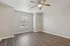 Bright, spacious room with elegant wood flooring, ceiling fan, and ample natural light streaming through a large window.