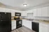 Modern kitchen with sleek black appliances, elegant white cabinetry, and stylish backsplash tiles.