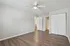 Bright and airy bedroom with stylish wood flooring, a ceiling fan, and convenient access to bathroom and closet.