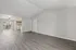 Bright, open-concept living area with elegant wood flooring, natural light pouring through large sliding glass doors, and convenient in-unit laundry space.