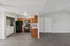 Modern open-plan kitchen with sleek appliances, stylish wood cabinetry, and a convenient in-unit laundry space.