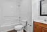 Bright and modern bathroom featuring a sleek bathtub, elegant fixtures, and a stylish vanity with a large mirror.