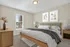 Bright and cozy bedroom featuring a plush bed with elegant linens, modern artwork, and a sunlit window creating a serene atmosphere.