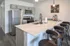 Modern kitchen with sleek stainless steel appliances, elegant marble countertop, and stylish bar seating.