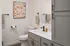Chic modern bathroom with sleek cabinetry, elegant fixtures, abstract wall art, and inviting neutral tones.