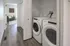 Modern apartment with sleek laundry area, featuring washer and dryer adjacent to a cozy seating nook with natural light.