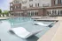 Inviting outdoor pool area with modern lounge chairs, surrounded by elegant architecture and abundant natural light.