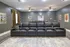 Chic home theater with plush black reclining seats, ambient lighting, and vintage movie posters creating a cinematic atmosphere.