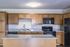 Contemporary kitchen with granite countertops, elegant wood cabinetry, and modern appliances for a sleek and functional space.