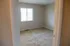 Bright and inviting empty room with soft carpet and a large window, perfect for customization and personal touch.
