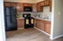 Charming kitchen with modern appliances, warm wood cabinetry, and sleek countertops, perfect for culinary creations.