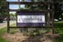 Inviting Cedar Ridge Townhomes and Apartments sign set against lush green surroundings, showcasing a serene living environment.