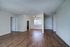 Royal Breeze Apartments Inc, interior, wood floor, living room, dining room, front entrance, window and blinds, ceiling fan, doorway to bedroom, kitchen, black refrigerator