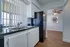 Royal Breeze Apartments Inc, interior, kitchen, dining room wood floor, white cabinets, black appliances, refrigerator, large window with blinds, ceiling fan