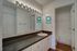 Royal Breeze Apartments Inc, interior, bathroom, spacious dark counter, large mirror, sink, white cabinets, wood floor, doorway to toilet and shower/tub