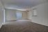 Royal Breeze Apartments Inc, interior, carpeted living room, window with blinds, ceiling fan, dining room, kitchen pass-through opening