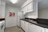 Royal Breeze Apartments Inc, interior, kitchen, tiled floor, white cabinets, dark counters, white appliance, stove/oven, refrigerator, dishwasher