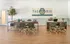 Elegant office space with stylish green chairs, hardwood flooring, and modern wooden desks in The Rio Apartments.